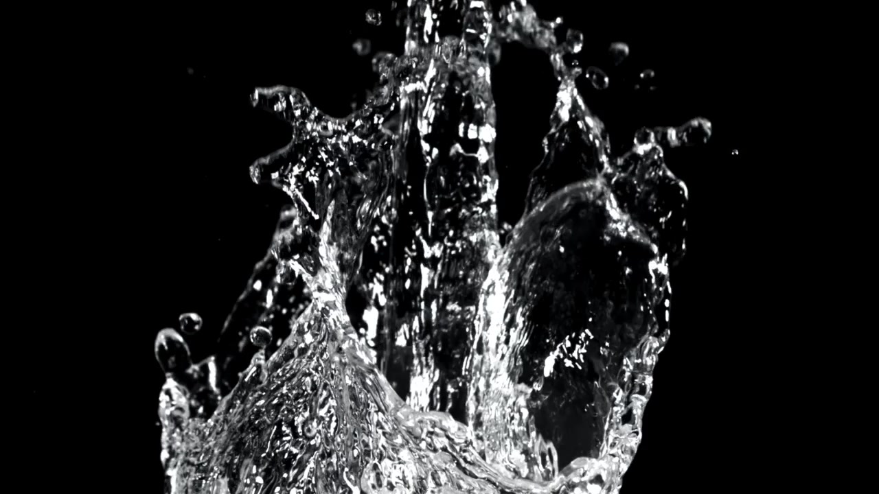 Vandsprøjt og dråber i slowmotion på sort baggrund