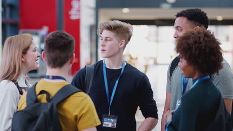 group of college student friends meeting and talking in busy communal campus building