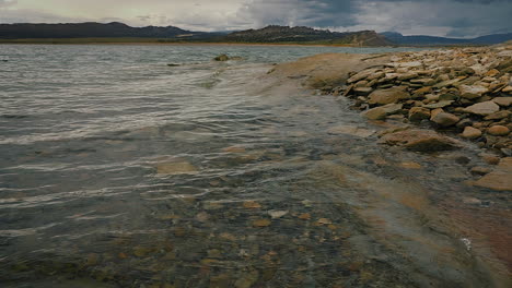 Wind-driven-Waves-In-The-Lake-With-Pebbles-And-Rocks