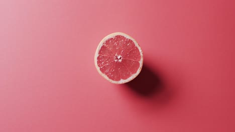 video of sliced red grapefruit with copy space over red background