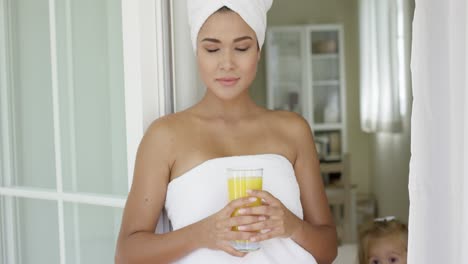 beautiful woman wrapped in towel looking outside