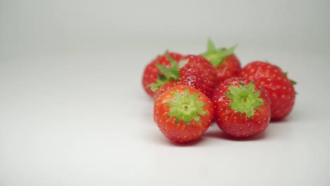 six red, delicious, and fresh strawberries turning clockwise - close up shot
