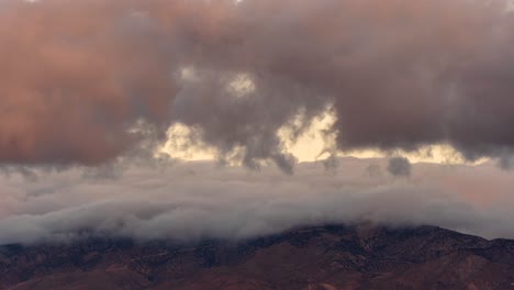 las nubes caen de las montañas en el rápido lapso de tiempo de la puesta del sol