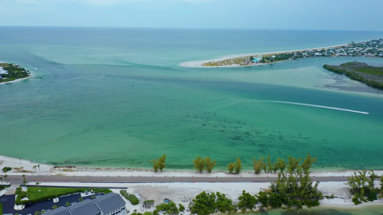 Turquoise Gulf waters sweep through Stump Pass Inlet at the southern tip of Manasota Key on Florida’s Gulf Coast, shaping sandbars, tidal channels, and shoreline curves beside nearby homes and beaches