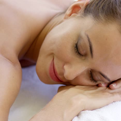 Woman-with-chin-on-folded-towel-smiles