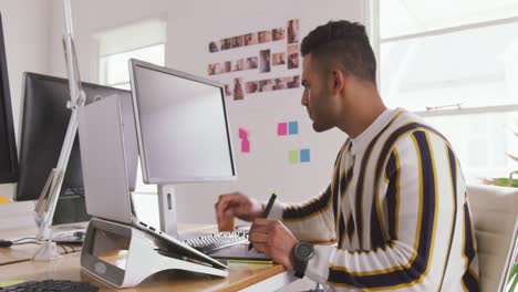 hombre de raza mixta trabajando en una oficina creativa
