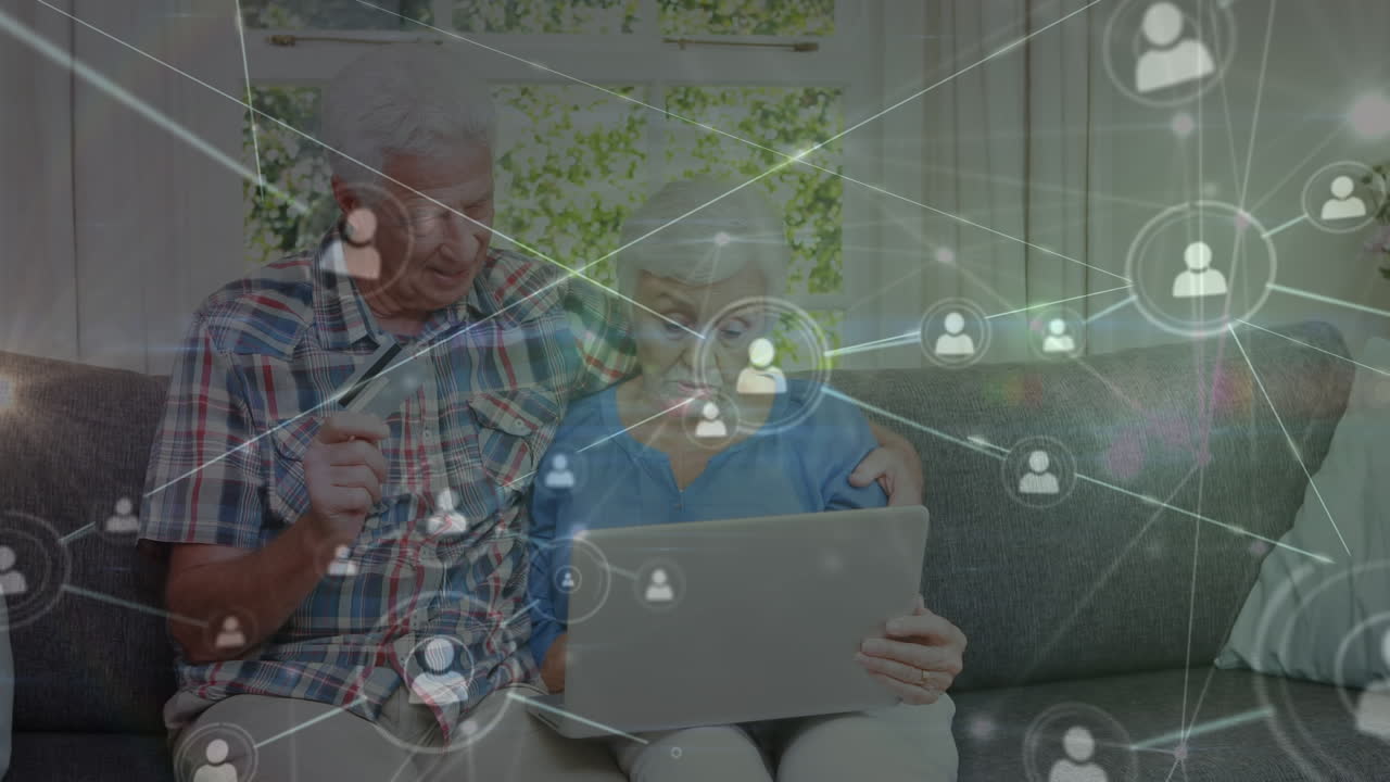 Animation of network of connections with icons over senior caucasian couple using laptop