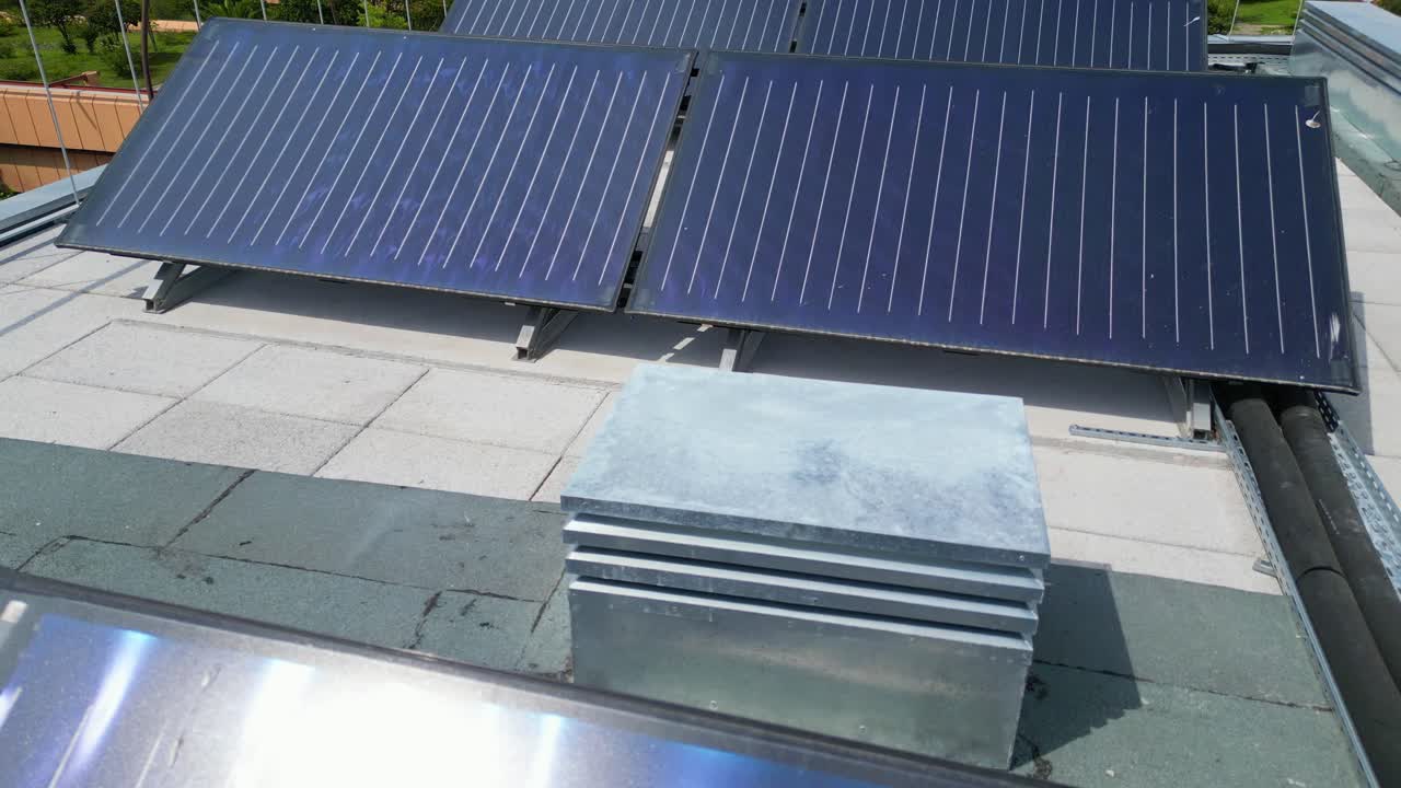 Flying over solar panels with the sun refleting at them on the top of a building in Lisbon,Portugal