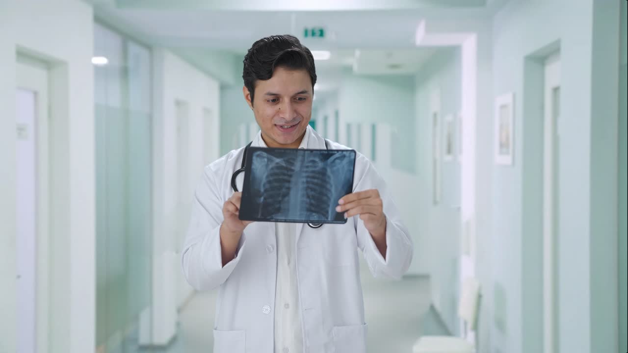 médico indio feliz comprobando el informe de rayos x