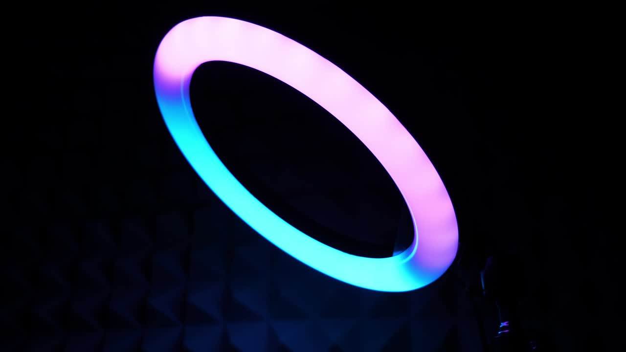 The ring RGB lamp flickers turquoise and lilac. Multicolored light.