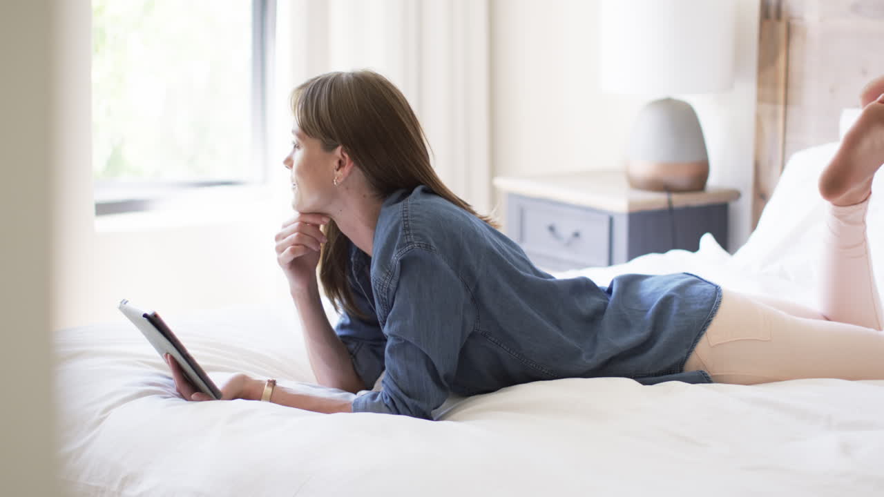 중년 백인 여성이 집에서 침대에 누워 있습니다.