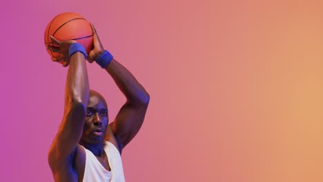 Video-Eines-Afroamerikanischen-Männlichen-Basketballspielers,-Der-Einen-Ball-Auf-Rosa-Bis-Orangefarbenem-Hintergrund-Wirft