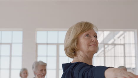 yoga-class-portrait-beautiful-old-woman-practicing-warrior-pose-enjoying-group-physical-fitness-workout-in-studio