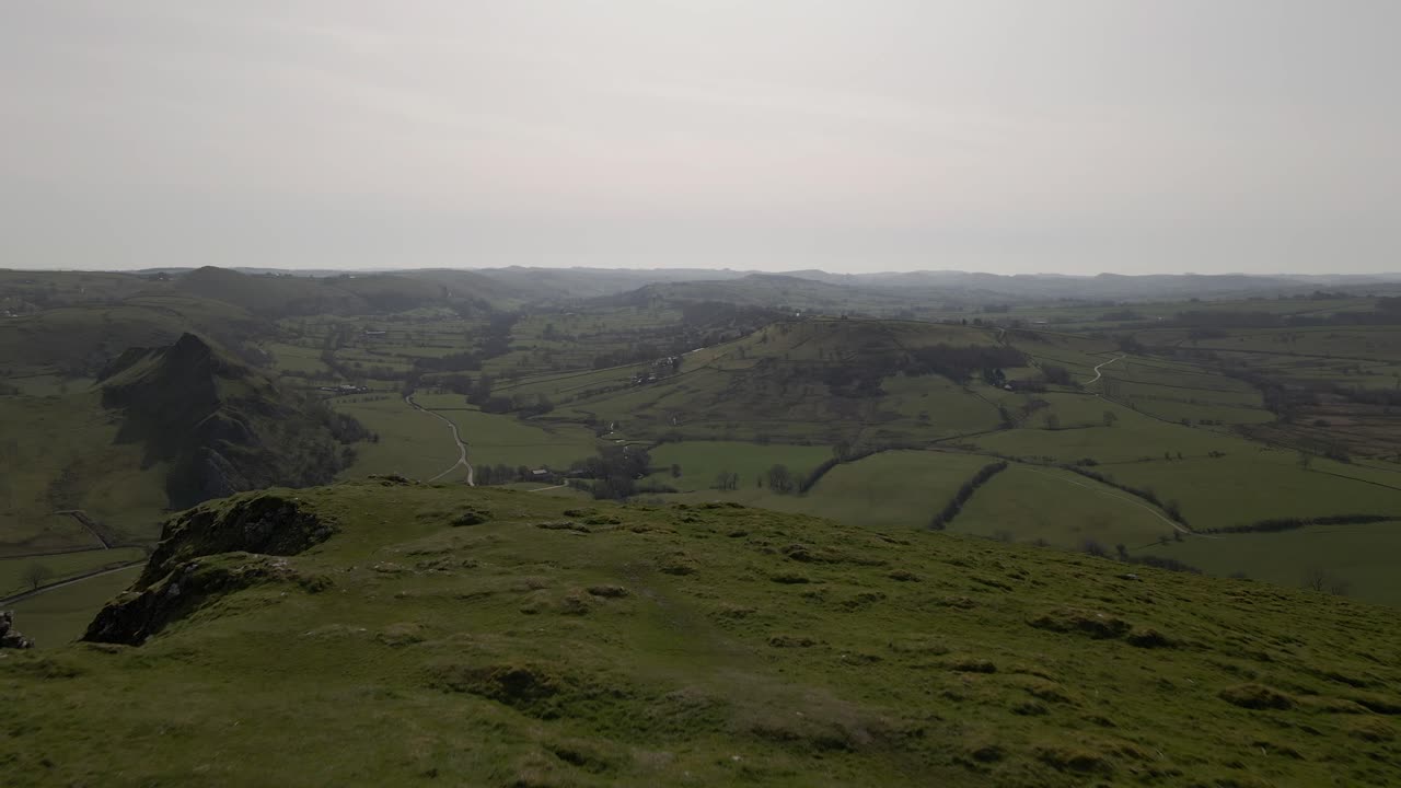 4k 드론 영상이 산 정상 위로 날아가서 넓게 열린 계곡을 드러냅니다.