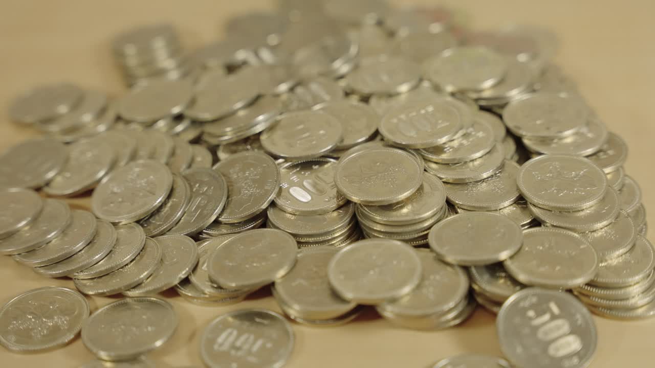 monedas japonesas, tumbadas en la mesa, tiro panorámico cercano