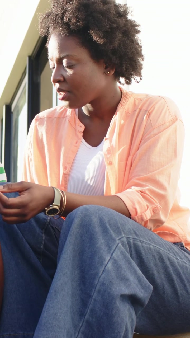 Vertical video: Listening woman shifting, leaning on stoop as child hand entering holding blue cup