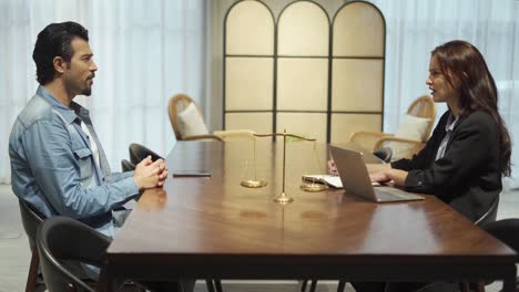 pareja hablando y trabajando con computadora portátil juntos en la oficina. mujer de negocios tomar nota de la discusión con el cliente. abogado escribir un mensaje de una conversación con un cliente.