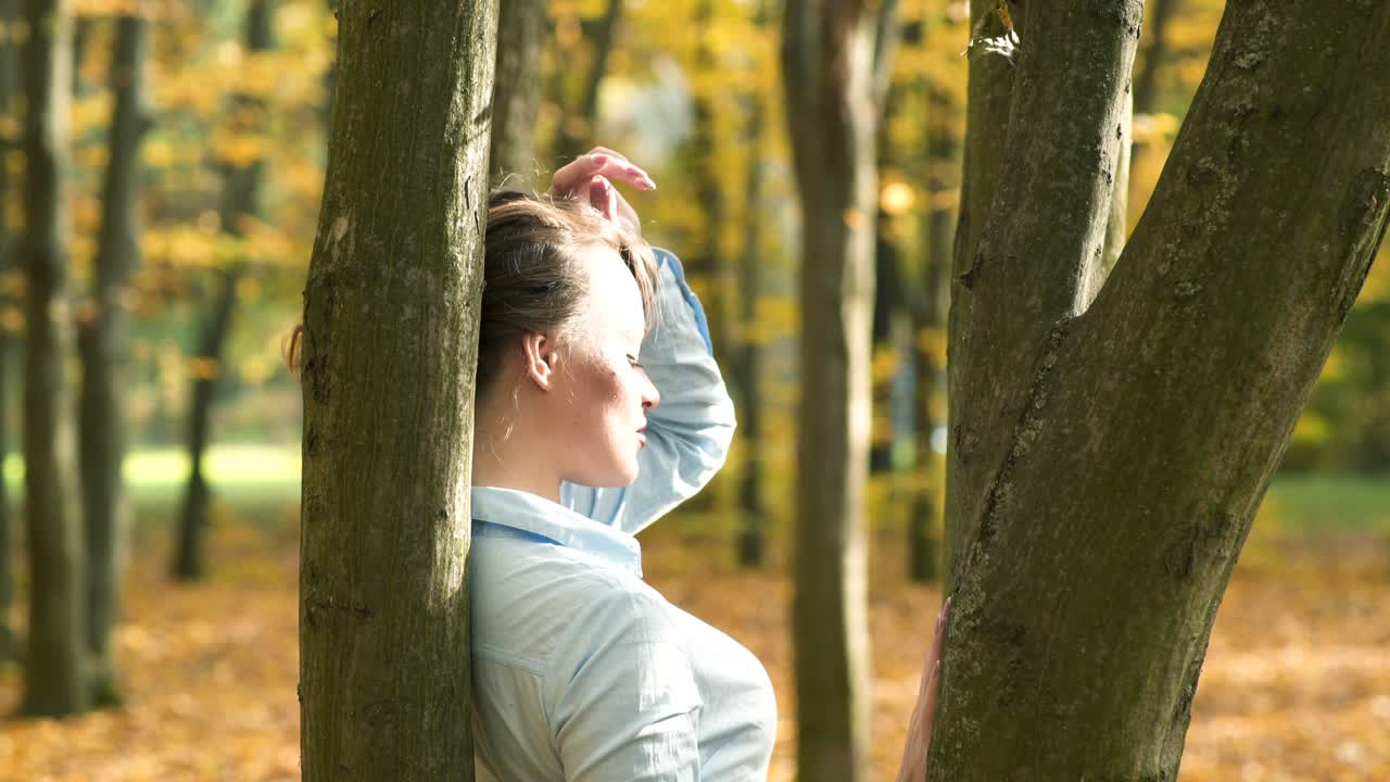 Beautiful female dreaming in the autumn park. Cheerful beautiful girl outdoors on beautiful fall day