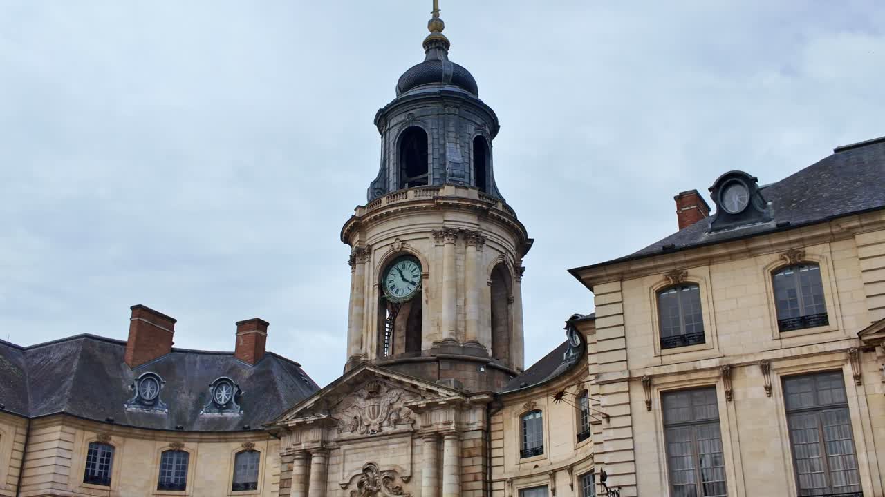 The iconic Cock tower of Hôtel de Ville in Rennes, France, features Roman numerals and intricate stonework beneath a domed roof, push-in shot emphasizing neoclassical architectural details