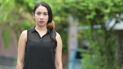 young beautiful asian businesswoman smiling with arms crossed in the streets outdoors