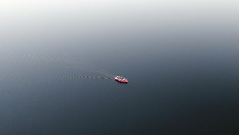 slow moving red boat in the ocean