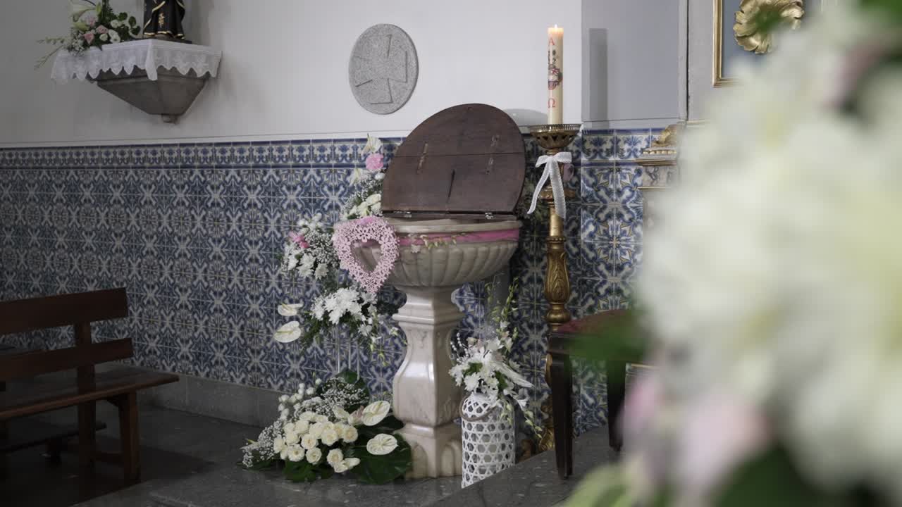Church baptismal font adorned with floral arrangements indoors