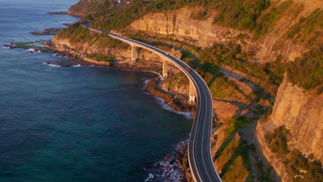 picturesque view of the sea and coastline with idyllic cliffs by the sea cliff bridge in nsw australia - aerial shot