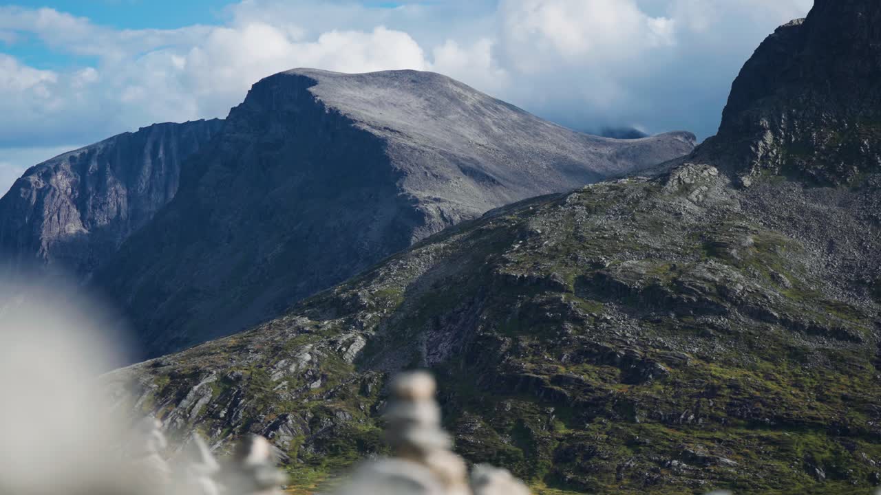 el desolado valle está rodeado de altas montañas grises, mientras que las nubes tormentosas giran en el cielo por encima