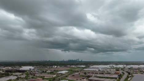 cloudy stormy skies over meadowvale with the city skyline in the distance, aerial shot, hyperlapse