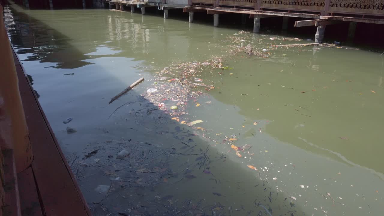 A layer of sludge and garbage floating in the water at the docks show the problem with pollution in the sea.