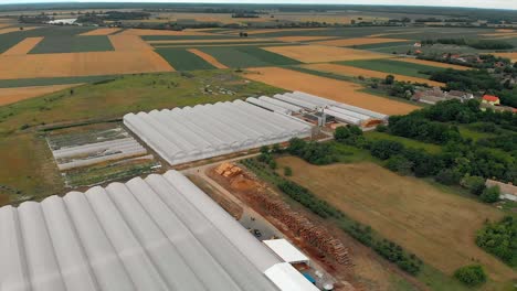 Filas-De-Invernaderos-Blancos-Ubicados-Entre-Tierras-De-Cultivo-Fértiles,-Condado-De-Osijek-baranja,-Croacia,-Antena