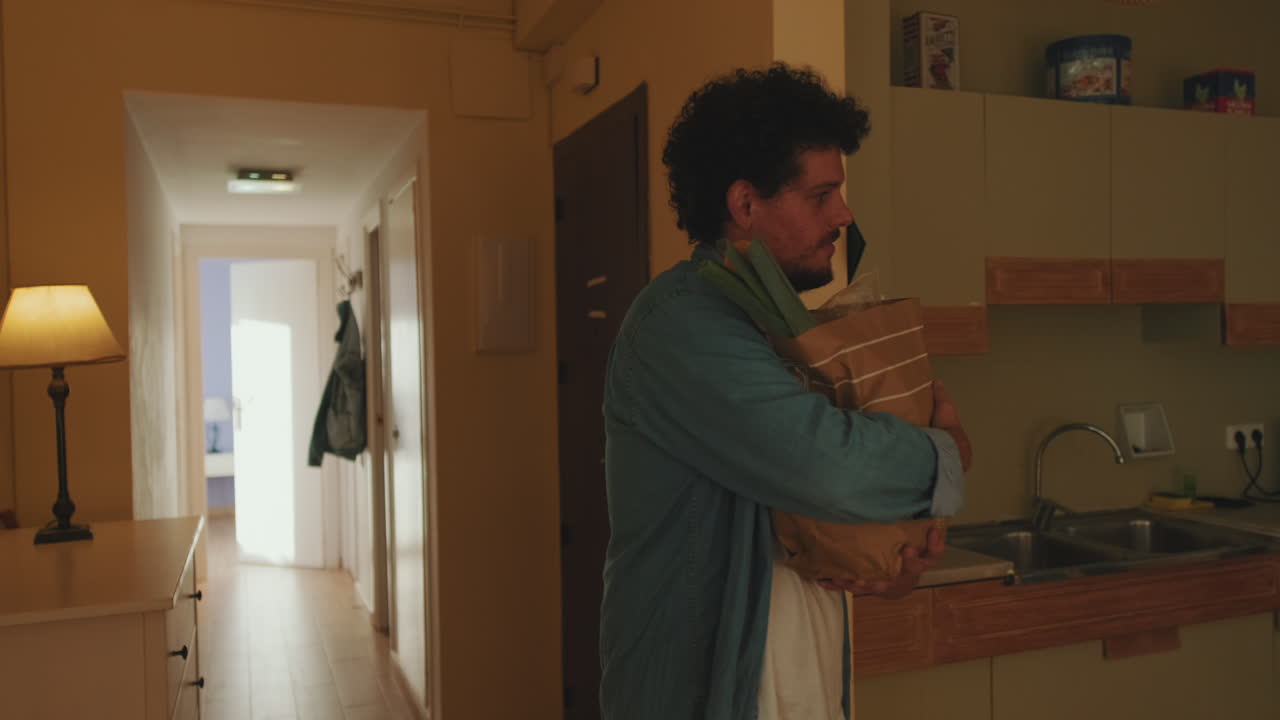 Man with groceries in hallway