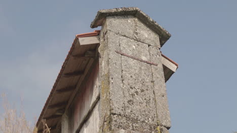 low angle close up shot of a granary alled espigueiro in a rural village on a hill friaes tras-os-montes portugal