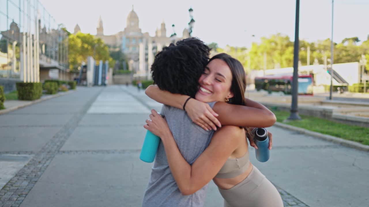 Due giovani donne felici che si abbracciano e parlano all'aperto