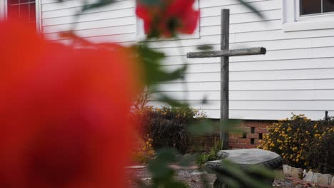 christian cross with out of focus red rose