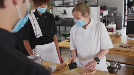 백인 여성 요리사 는 얼굴 마스크 를 쓰고 다양한 집단 을 가르치고 있다