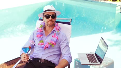 Relaxed-man-drinking-cocktail-on-deck-chair