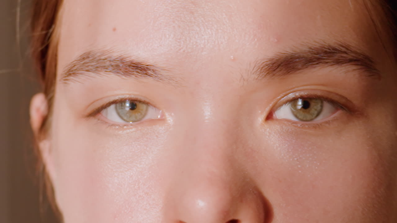 Extreme Closeup Caucasian Woman Winking Playfully With Green Eyes And Shimmering Skin Under Warm Sunlight, Eyelashes And Eyelid Detail For Beauty Tutorial, Cosmetic Advertising And Emotive Expression