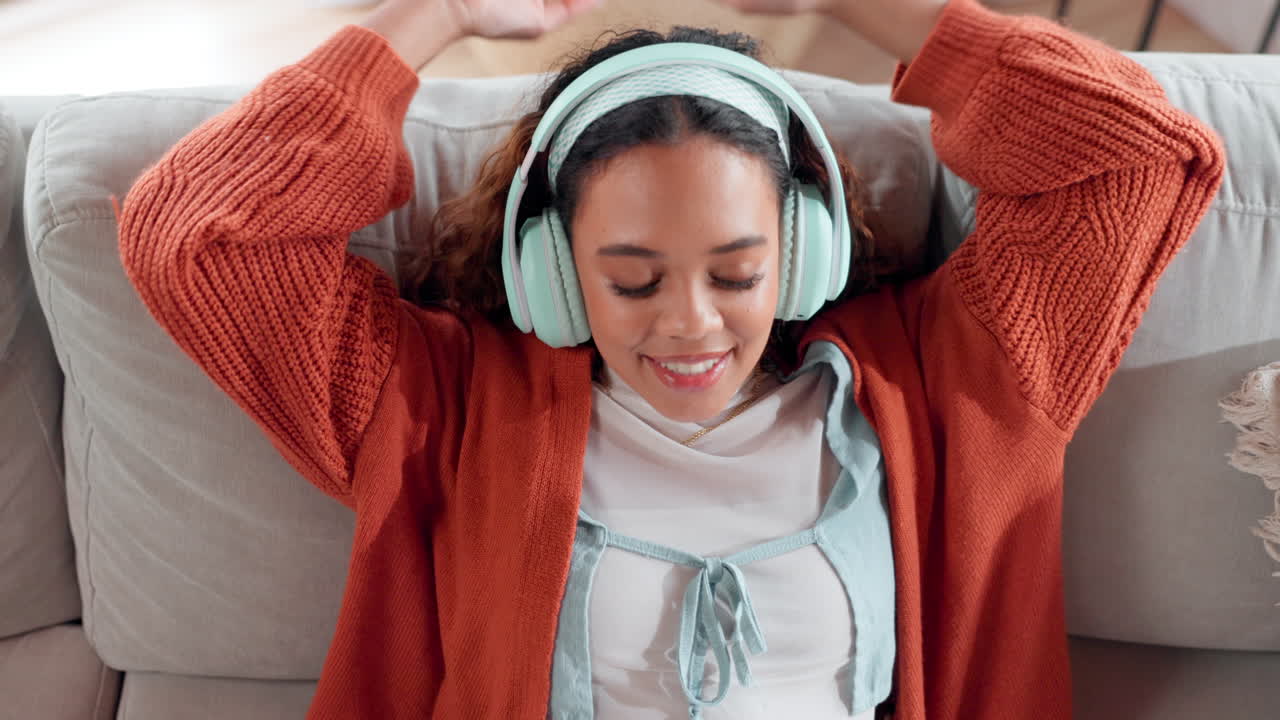 mujer relajándose en el sofá con auriculares