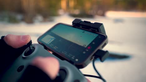 Nahaufnahme-Einer-Person,-Die-Im-Winter-Eine-Drohne-Im-Sonnenuntergang-Fliegt