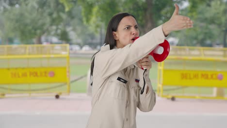 Indian-female-police-officer-controlling-crowd-using-megaphone