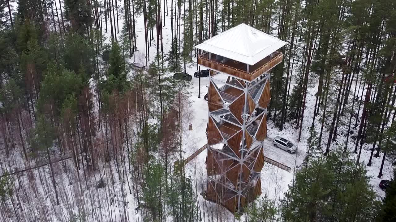 acercándose a la vista aérea de drones de una torre de observación en un pantano durante el invierno