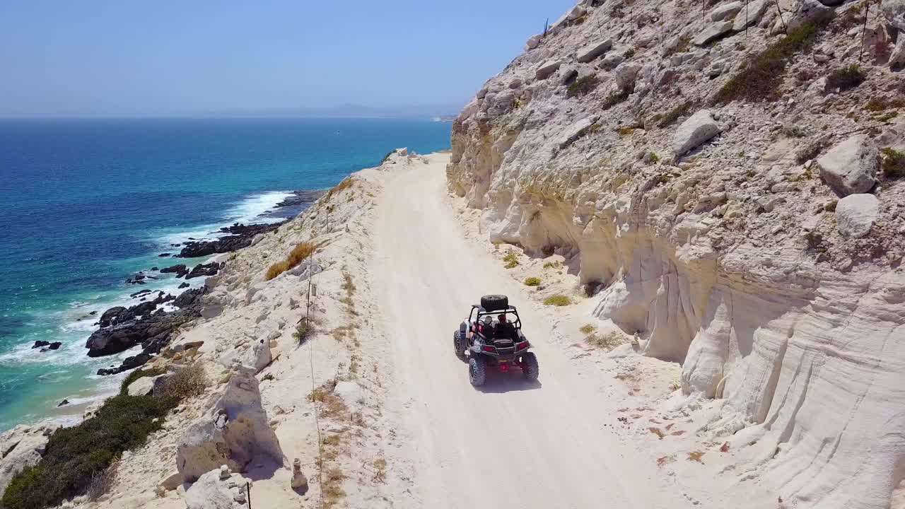 Bella ripresa aerea di un ATV che sfreccia su una strada sterrata vicino a Cabo Baja, Messico 1.