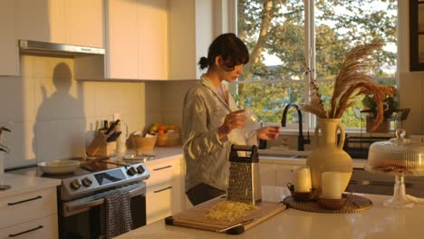 pregnant woman preparing food in the kitchen in sunset ambient light