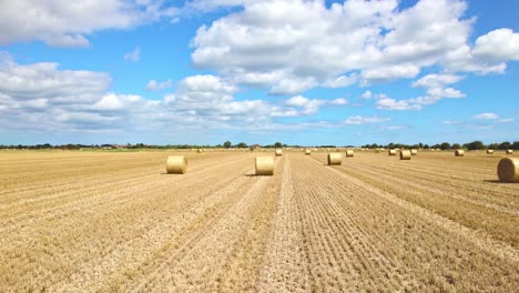 aerial footage captures the serenity of wind turbines in a lincolnshire farmer's freshly harvested field, with golden hay bales adding a touch of charm to the scene