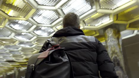 man walking through a modern metro station