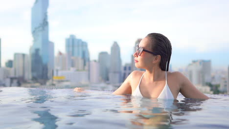 Un-Primer-Plano-De-Una-Mujer-Apoyada-En-El-Borde-De-La-Piscina-De-Un-Centro-Turístico