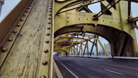 High-quality-low-angle-footage-looking-through-the-arches-of-the-yellow-bridge-in-downtown-Sacramento-appears-like-a-tunnel-on-a-foggy-overcast-day