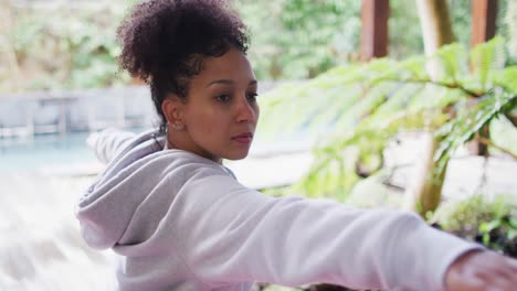 african american woman performing stretching exercise at vacation home