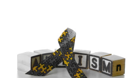 awareness ribbon falling onto blocks spelling autism